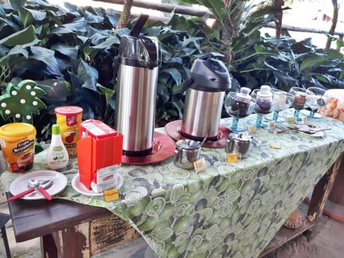 a table with two kettles on top of it at Pousada Portal do Cacau-Petfriendly in Camburi