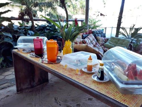 a table with food and drinks on top of it at Pousada Portal do Cacau-Petfriendly in Camburi