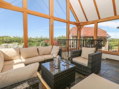 a conservatory with a couch and chairs and a table at Groomes Country House in Bordon