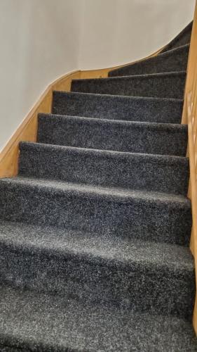 a set of stairs in a building with grey carpet at Bell Gate House in Leicester