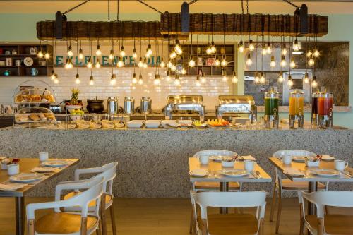 ein Restaurant mit Tischen und Stühlen und eine Bar in der Unterkunft Fiesta Inn Express Ciudad de México Forum Buenavista in Mexiko-Stadt