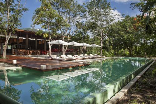 een zwembad met stoelen en parasols voor een gebouw bij The Explorean Cozumel All Inclusive in Cozumel