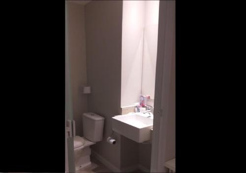 a bathroom with a sink and a toilet and a window at Jandira Premiêr Hotel in Jandira