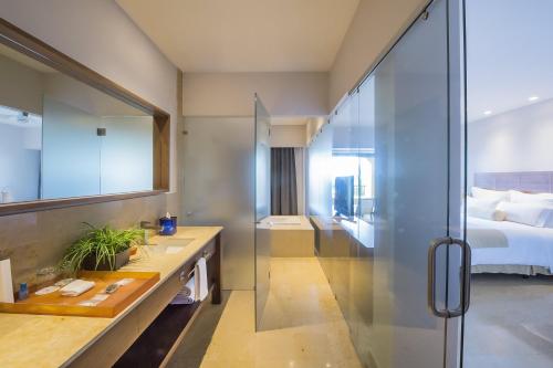 a bathroom with a glass shower and a bed at Grand Fiesta Americana Los Cabos All Inclusive Golf & Spa in Cabo San Lucas