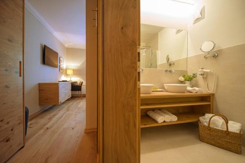 a bathroom with a sink and a mirror at Alpines Gourmet Hotel Montanara in Flachau