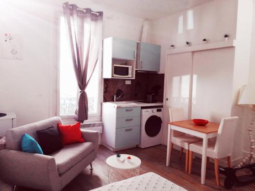 ein Wohnzimmer mit einem Sofa und einem Tisch in der Unterkunft Studio dans un quartier résidentiel à Montrouge avec le métro à 2 min in Montrouge