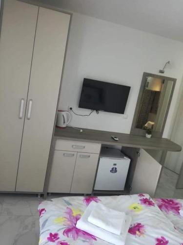 a bedroom with a desk with a television and a bed at VILLA EKATERINA in Ohrid
