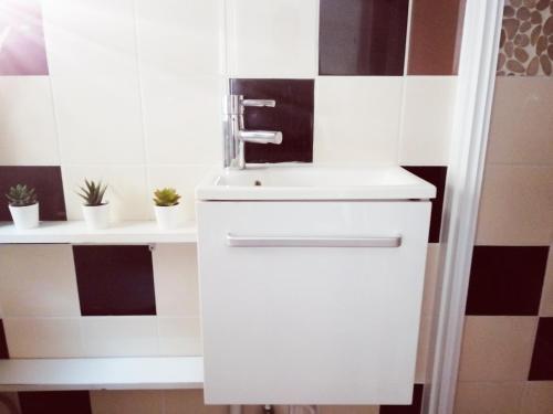 ein Badezimmer mit einem weißen Waschbecken und einer schwarz-weißen Wand in der Unterkunft Studio dans un quartier résidentiel à Montrouge avec le métro à 2 min in Montrouge
