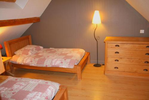 a bedroom with two beds and a dresser and a lamp at Gite Du Vigneron in Turckheim