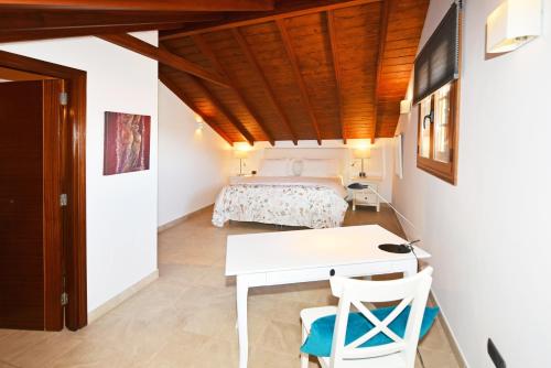 Un dormitorio con una cama, un escritorio y una mesa. en Apartamentos La Casa Verde, en Puerto de la Cruz