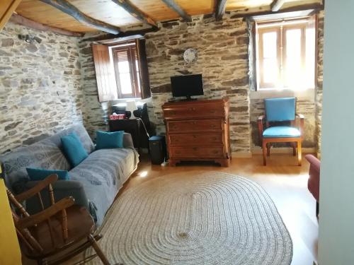 a living room with a couch and a tv at Casa do Alto - Benfeita in Benfeita