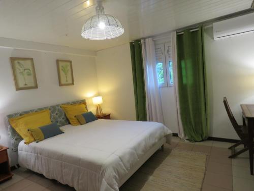 - une chambre dotée d'un grand lit avec des oreillers jaunes et bleus dans l'établissement Serenity, à Gros-Morne