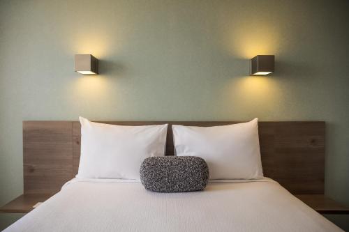 a bedroom with a bed with two lights on the wall at One Puebla Serdan in Puebla