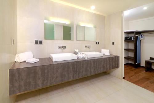 a bathroom with two sinks and two mirrors at Holiday Inn Express Mexico Aeropuerto by IHG in Mexico City