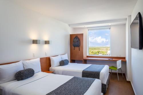 Ένα ή περισσότερα κρεβάτια σε δωμάτιο στο One Cancun Centro