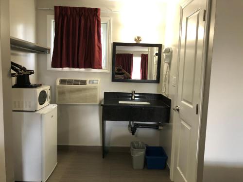 a kitchen with a sink and a refrigerator at Aquarius Motel in Perth