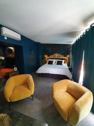 貝濟耶的住宿－Au secret des Brégines，一间卧室配有一张床和两把椅子