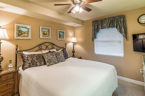 - une chambre avec un lit et un ventilateur de plafond dans l'établissement Pelican Isle Condominiums, à Fort Walton Beach