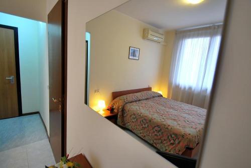 a reflection of a bedroom with a bed in a mirror at Il Piccolo Golf in Muggiò