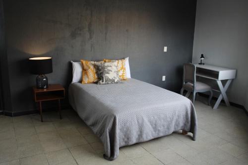 a bedroom with a bed and a table and a piano at Casa Arrayan in Guadalajara