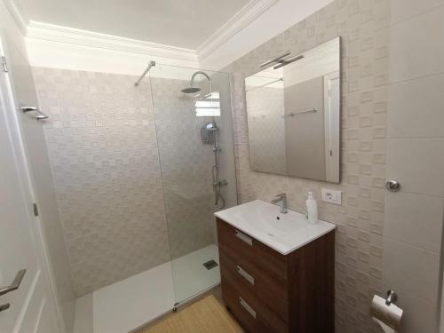 a bathroom with a sink and a shower with a mirror at Apartamento vista al mar Playa Las Américas in Arona