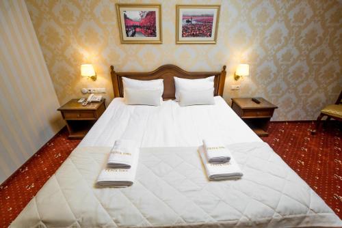 a bedroom with a large white bed with two tables at FENIX TOWN in Vinnytsya