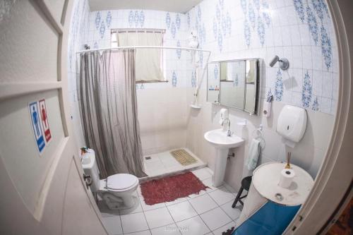 a bathroom with a shower and a sink and a toilet at Hostel Petrópolis in Petrópolis