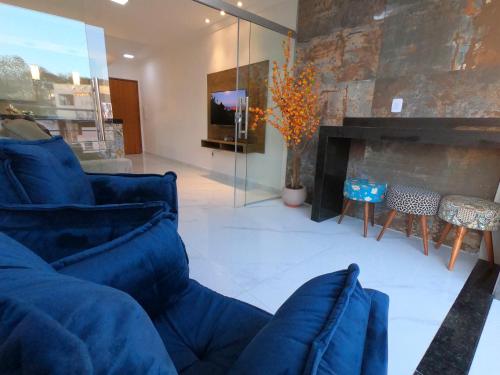 a living room with a blue couch and a fireplace at TH Flats GV Shopping 502 in Governador Valadares