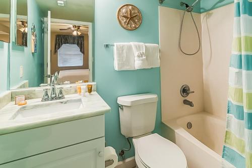 a bathroom with a toilet and a sink and a shower at Pelican Isle Condominiums in Fort Walton Beach