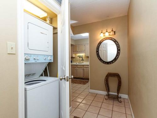 a kitchen with a washing machine and a mirror at Island Echos 6th Floor Condos in Fort Walton Beach