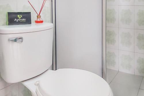 a bathroom with a toilet with a box on top of it at HOTEL HOSPEDAJE CANEY "Descanso & Tradición" Ayenda 1422 in Cali