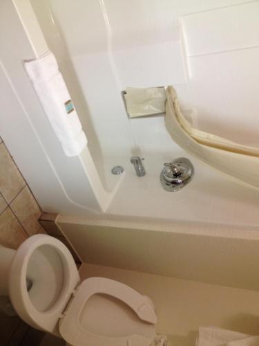 a bathroom with a toilet and a sink at Howard Johnson by Wyndham Lubbock TX in Lubbock