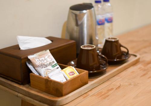 een dienblad met een koffiezetapparaat en kopjes op een tafel bij Pasola 
