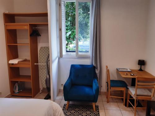 - une chambre avec une chaise bleue, un bureau et une fenêtre dans l'établissement Appartement AAD1 Clamart 200 m du Tramway T6 st pavé blc avec cuisine séparée, à Clamart