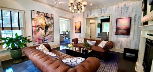 a living room with brown leather couches and a fireplace at White Porch Inn in Provincetown