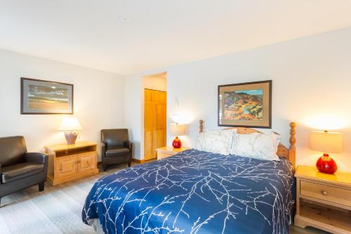 a bedroom with a blue bed and two chairs at FABULOUS LOCATION Private Hot Tub, NO Car needed, Sleeps 8 in Whistler