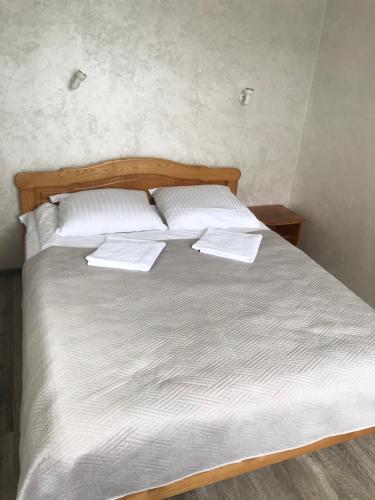a bed with white sheets and pillows on it at готель Вікторія in Volovets
