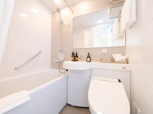 a bathroom with a toilet and a sink and a tub at Best Western Hotel Fino Tokyo Akasaka in Tokyo