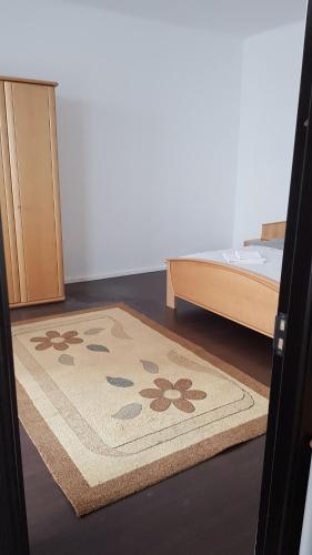 een kamer met een tapijt op de vloer naast een bed bij Apartament 13 Central in Târgu-Mureş
