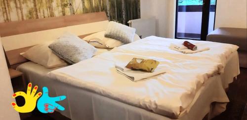 a large white bed with two plates of food on it at Ubytovanie na súkromí KIKA in Santovka