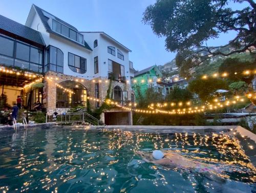 a swimming pool in front of a house with lights at Le vent Tam Đảo homestay in Tam Ðảo