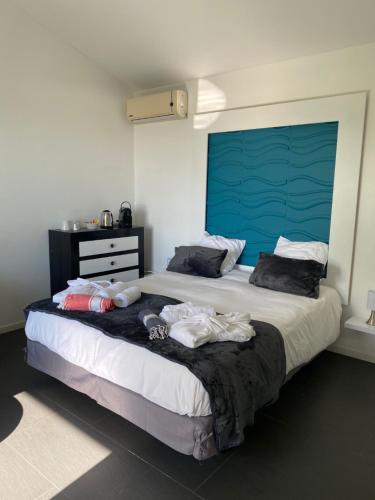 a bedroom with a large bed with clothes on it at Chambres d'hôtes CASA COSY in Les Avirons