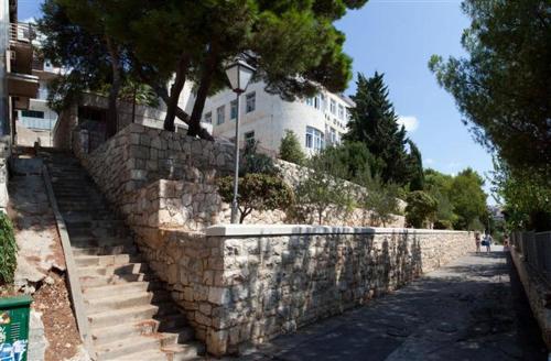 eine Steinmauer mit einer Treppe neben einem Gebäude in der Unterkunft Branka Burak in Hvar