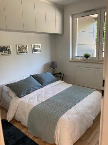 a bedroom with a large bed with a window at Apartament Wiosenna in Białystok