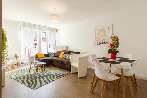 un salon avec un canapé, une table et des chaises dans l'établissement Travel Homes -The Ecolier, 1min from Little Venice, à Colmar