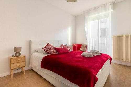 une chambre avec un grand lit avec une couverture rouge dans l'établissement Travel Homes -The Ecolier, 1min from Little Venice, à Colmar