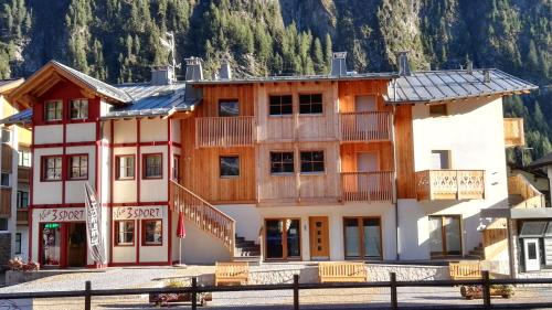 a hotel in the mountains with a building at Cèsa Baissa in Campitello di Fassa