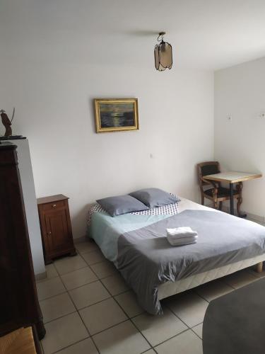 une chambre avec un lit et une table dedans dans l'établissement Appartement de Plage, à Bréhec