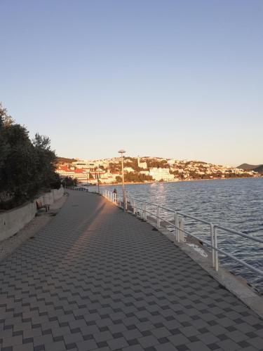a walkway next to a body of water at Apartmani Leženić Dada in Neum
