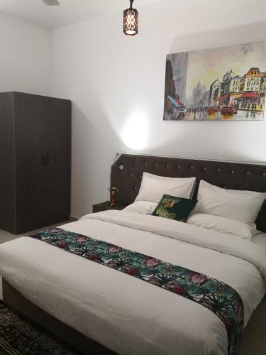 a bedroom with a large bed with white sheets at Aryaf Nizwa Hotel Apartments in Nizwa